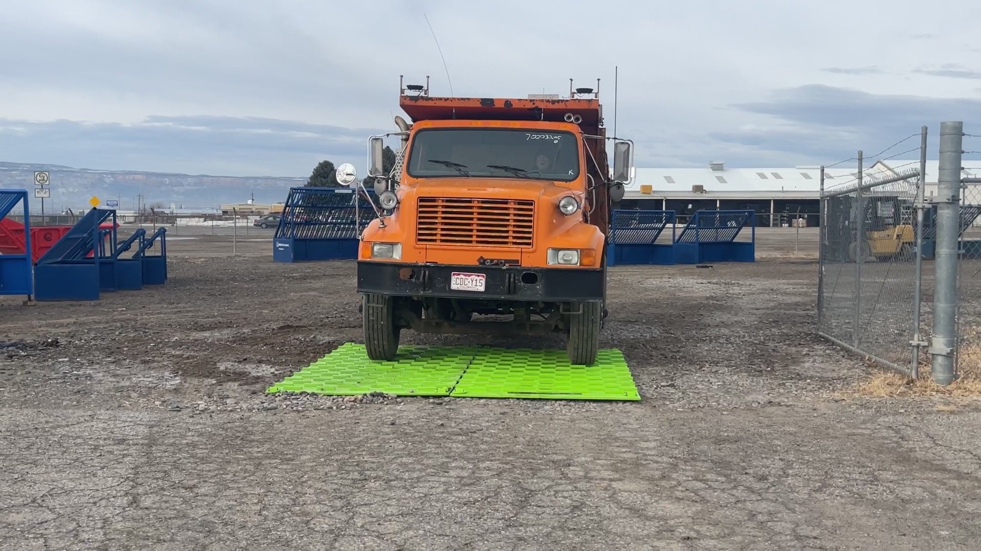 A dump truck tracking off mud using a trackout pad.